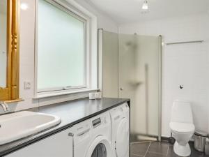 uma casa de banho branca com um lavatório e uma máquina de lavar roupa em Holiday Home Vilhelm in SE Jutland by Interhome em Give