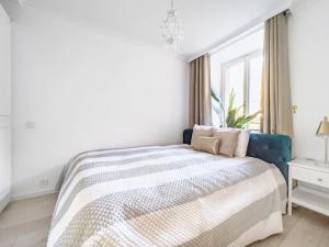 a white bedroom with a bed and a window at Chic 2 bedroom apartment near Chillion castle in Veytaux
