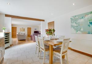 a kitchen and living room with a wooden table and chairs at Oak Lodge in Alderford