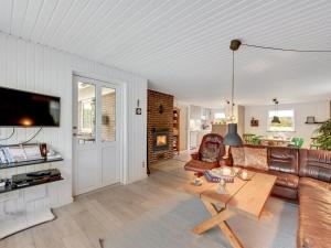 a living room with a couch and a table at Holiday Home Tholf - 100m to the inlet by Interhome in Ulfborg