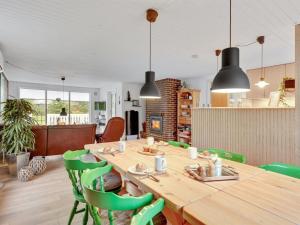 a dining room with a wooden table and green chairs at Holiday Home Tholf - 100m to the inlet by Interhome in Ulfborg +17 photos