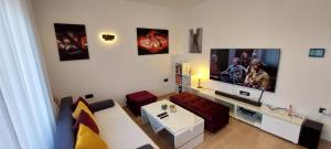 uma sala de estar com um sofá e uma televisão de ecrã plano em Apartman Perunika em Selce