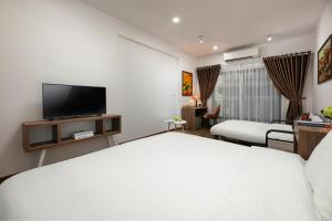 a hotel room with a bed and a flat screen tv at Hanoi Saga Hotel in Hanoi