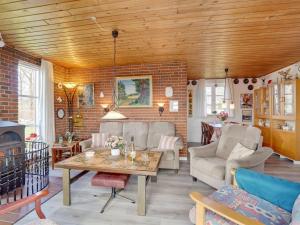 sala de estar con mesa y pared de ladrillo en Holiday Home Tuki - all inclusive - 700m to the inlet by Interhome, en Struer