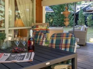 a table with a bottle of wine and glasses on a porch at Holiday Home Ellica - 3km from the sea in SE Jutland by Interhome in Give