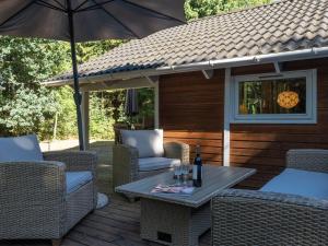 a patio with a table and chairs and an umbrella at Holiday Home Ellica - 3km from the sea in SE Jutland by Interhome in Give