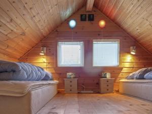 a room with two beds in a wooden attic at Holiday Home Terese - 45km from the sea in Western Jutland by Interhome in Grindsted