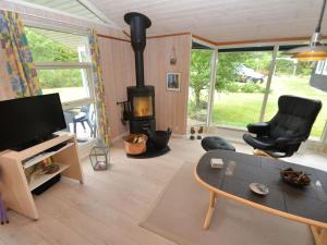 sala de estar con estufa de leña y mesa en Holiday Home Emille - 300m to the inlet in The Liim Fiord by Interhome en Struer