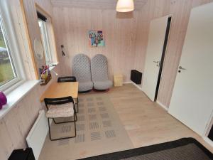 een kleine kamer met stoelen, een tafel en een bureau bij Holiday Home Emille - 300m to the inlet in The Liim Fiord by Interhome in Struer