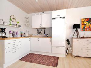 eine Küche mit weißen Schränken und einem Kühlschrank in der Unterkunft Apartment Rejhana - 500m to the inlet by Interhome in Øsløs + 8 Fotos