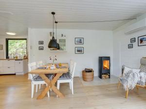 jadalnia ze stołem, krzesłami i kominkiem w obiekcie Holiday Home Aina - 250m to the inlet in The Liim Fiord by Interhome w mieście Hjerm