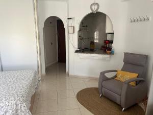 sala de estar con silla y cocina en Estudio fran centro internacional, en Algarrobo Costa