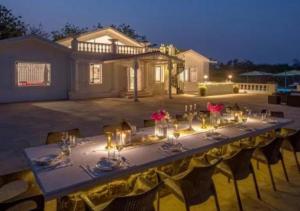 a long table with candles and flowers on it at SaffronStays Brunton House, Alibaug - luxury pool villa near Awas Beach in Alibaug