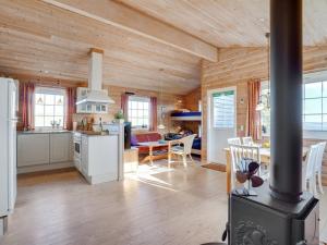 a kitchen and living room with wooden walls and a stove at Holiday Home Lenita - 30m to the inlet in The Liim Fiord by Interhome in Thisted