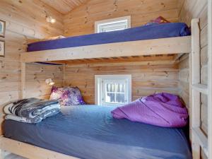 a bedroom with two bunk beds in a log cabin at Holiday Home Lenita - 30m to the inlet in The Liim Fiord by Interhome in Thisted