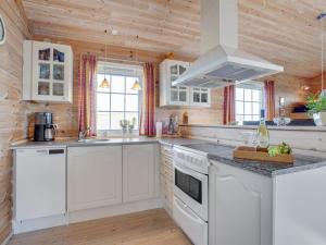 a kitchen with white appliances and wooden walls at Holiday Home Lenita - 30m to the inlet in The Liim Fiord by Interhome in Thisted