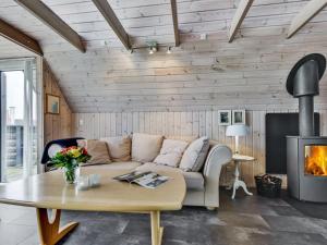 uma sala de estar com um sofá e uma lareira em Holiday Home Leve - 200m from the sea in SE Jutland by Interhome em Sønderby