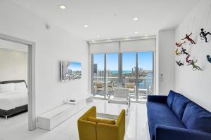 sala de estar con sofá azul y cama en Modern Penthouse condo with 2 story private terrace, en Hollywood