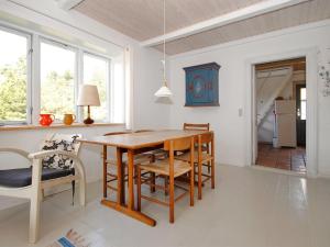 comedor con mesa de madera y sillas en Holiday Home Margrethe - 1-1km from the sea in NW Jutland by Interhome, en Bedsted Thy