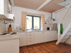 una cocina con armarios blancos y una ventana en Holiday Home Margrethe - 1-1km from the sea in NW Jutland by Interhome, en Bedsted Thy