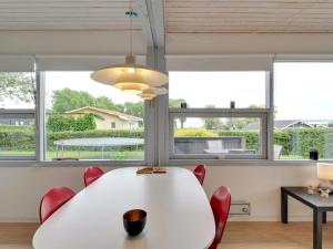 a white table and chairs in a room with windows at Holiday Home Giselle - 150m from the sea in SE Jutland by Interhome in Sønderby