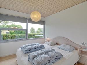 a bedroom with two beds and a large window at Holiday Home Giselle - 150m from the sea in SE Jutland by Interhome in Sønderby