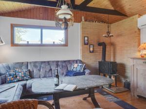 ein Wohnzimmer mit einem Sofa, einem Tisch und einem Herd in der Unterkunft Holiday Home Alpi - 250m to the inlet in The Liim Fiord by Interhome in Struer