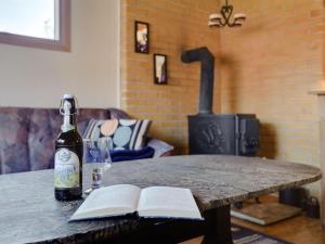 eine Flasche Wein und ein Buch auf einem Tisch mit einem Glas in der Unterkunft Holiday Home Alpi - 250m to the inlet in The Liim Fiord by Interhome in Struer