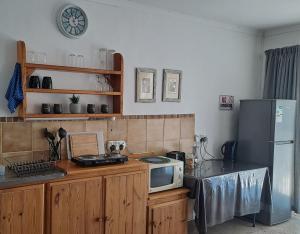 a kitchen with a counter with a microwave and a refrigerator at In Da Bush in Modimolle