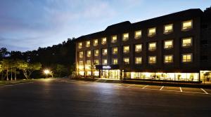 a large building with lights in a parking lot at Hotel Namoo Cheong-ju in Cheongju