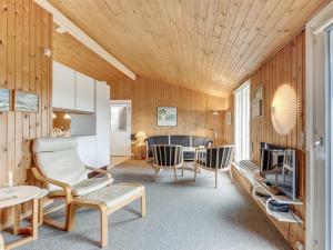 a living room with wooden walls and a table and chairs at Holiday Home Siri - 400m from the sea in NW Jutland by Interhome in Thisted