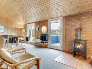 a living room with a brick wall and a wood stove at Holiday Home Siri - 400m from the sea in NW Jutland by Interhome in Thisted