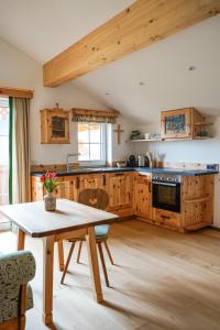 eine Küche mit Holzschränken und einem Holztisch in der Unterkunft Pension Haus am Wald in Strobl