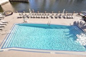 a large swimming pool with chairs and water at Modern Penthouse condo with 2 story private terrace in Hollywood