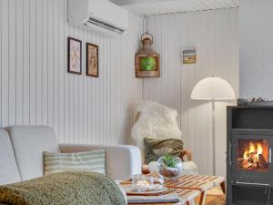 ein Wohnzimmer mit einem Sofa und einem Kamin in der Unterkunft Holiday Home Heera - 100m to the inlet in The Liim Fiord by Interhome in Lihme