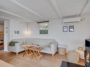 ein Wohnzimmer mit einem Sofa und einem Tisch in der Unterkunft Holiday Home Heera - 100m to the inlet in The Liim Fiord by Interhome in Lihme