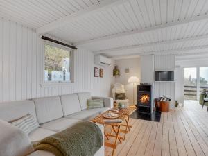 ein Wohnzimmer mit einer weißen Couch und einem Kamin in der Unterkunft Holiday Home Heera - 100m to the inlet in The Liim Fiord by Interhome in Lihme