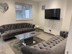 a living room with two couches and a flat screen tv at Modern Executive 2-Bed Apartment in London in London