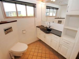 a white bathroom with a toilet and a sink at Holiday Home Aliza - 300m to the inlet in The Liim Fiord by Interhome in Roslev