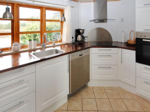 una cocina con armarios blancos y fregadero en Holiday Home Aliza - 300m to the inlet in The Liim Fiord by Interhome en Roslev