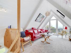 ein Wohnzimmer mit einem roten Sofa und einem Tisch in der Unterkunft Holiday Home Aaafke - all inclusive - 100m to the inlet by Interhome in Vinderup