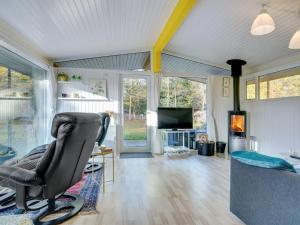 salon z krzesłem i telewizorem w obiekcie Holiday Home Calli - 400m to the inlet in The Liim Fiord by Interhome w mieście Højslev