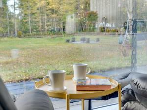 einen Tisch mit zwei Kaffeetassen und ein Buch darauf in der Unterkunft Holiday Home Calli - 400m to the inlet in The Liim Fiord by Interhome in Højslev