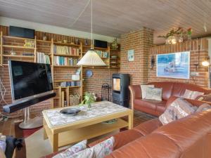 a living room with a couch and a tv at Holiday Home Ioar - 200m to the inlet by Interhome in Spottrup