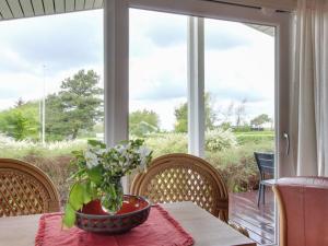 a table with a vase of flowers on a table in front of a window at Holiday Home Ioar - 200m to the inlet by Interhome in Spottrup