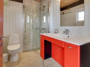 a bathroom with a red sink and a toilet at Holiday Home Ioar - 200m to the inlet by Interhome in Spottrup