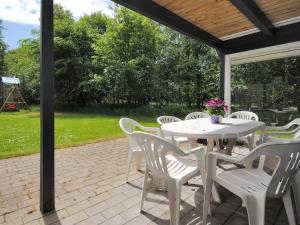 een witte tafel en stoelen op een patio bij Holiday Home Eliasine - 200m to the inlet in The Liim Fiord by Interhome in Øster Assels