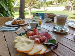 uma mesa de madeira com um prato de frutas e pão em Agroturisme Son Samà em Llucmajor