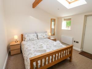 a bedroom with a bed with towels on it at 2 Barn Cottages in Halifax