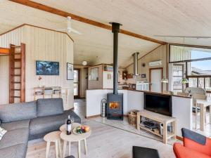 uma sala de estar com um sofá e uma lareira em Holiday Home Mervi - 300m to the inlet in The Liim Fiord by Interhome em Vinderup